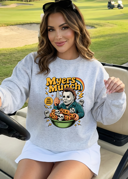 Woman wearing a sweatshirt with a Halloween-themed graphic in a golf cart on a golf course.