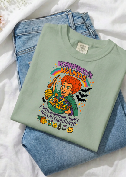 Light green t-shirt with colorful graphic design on a white surface with jeans.
