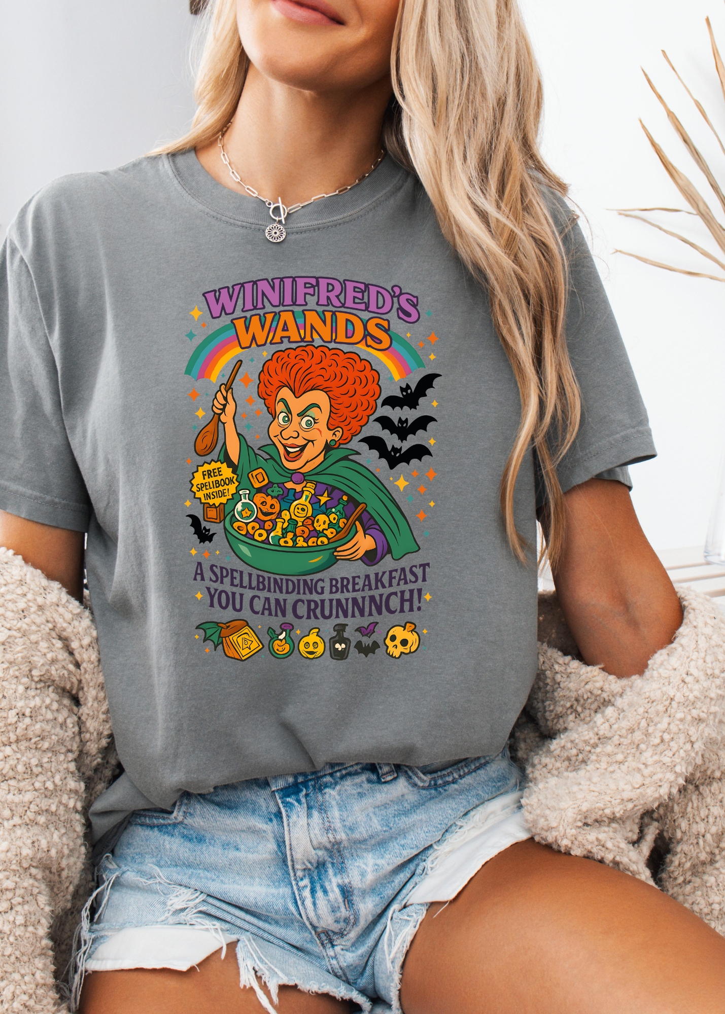 Person wearing a gray t-shirt with a colorful graphic design featuring a character and text.