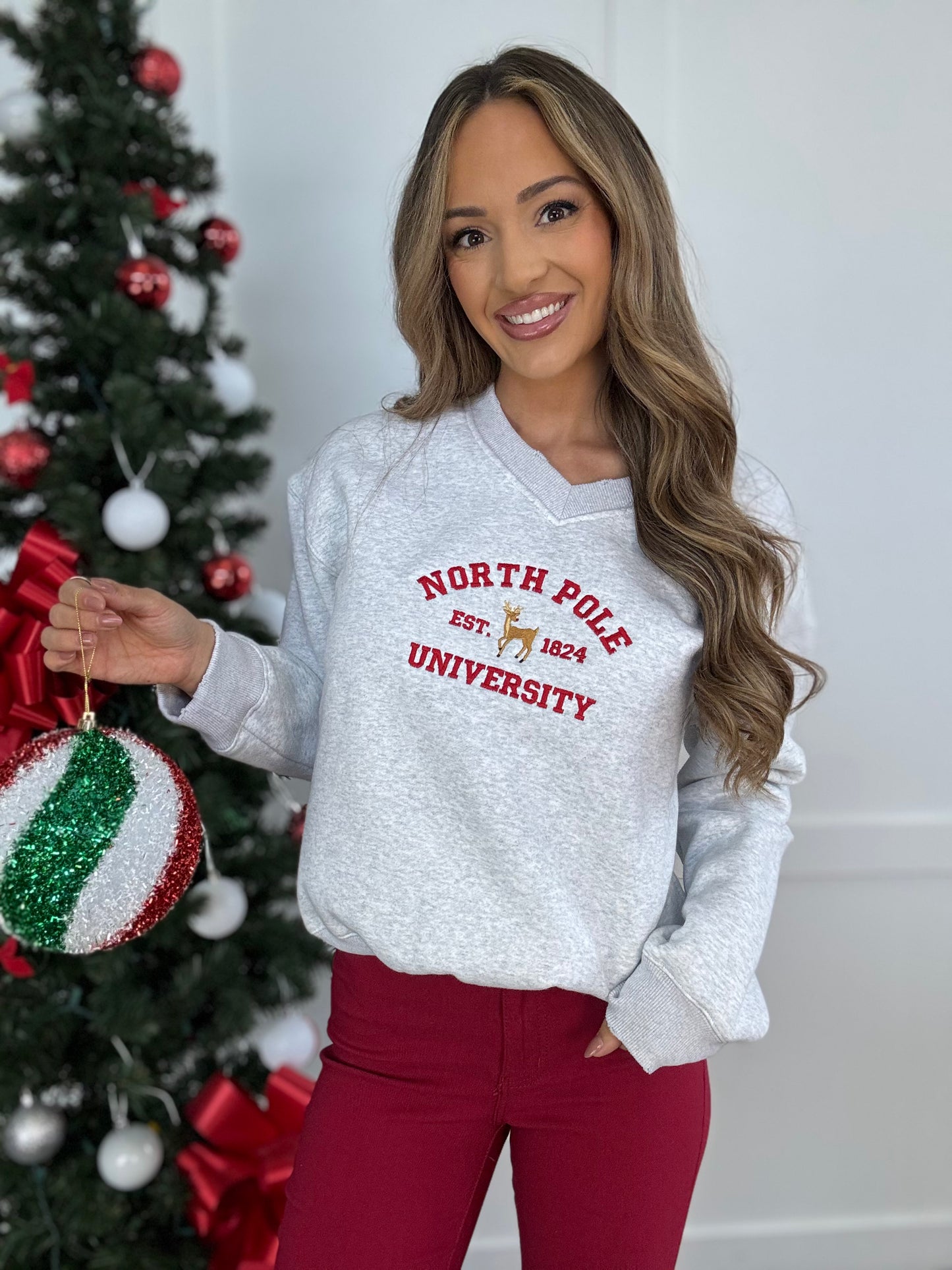 Shop Embroidered North Pole University V-Neck Crewneck online at Willow Boutique – best boutique for women’s fashion.