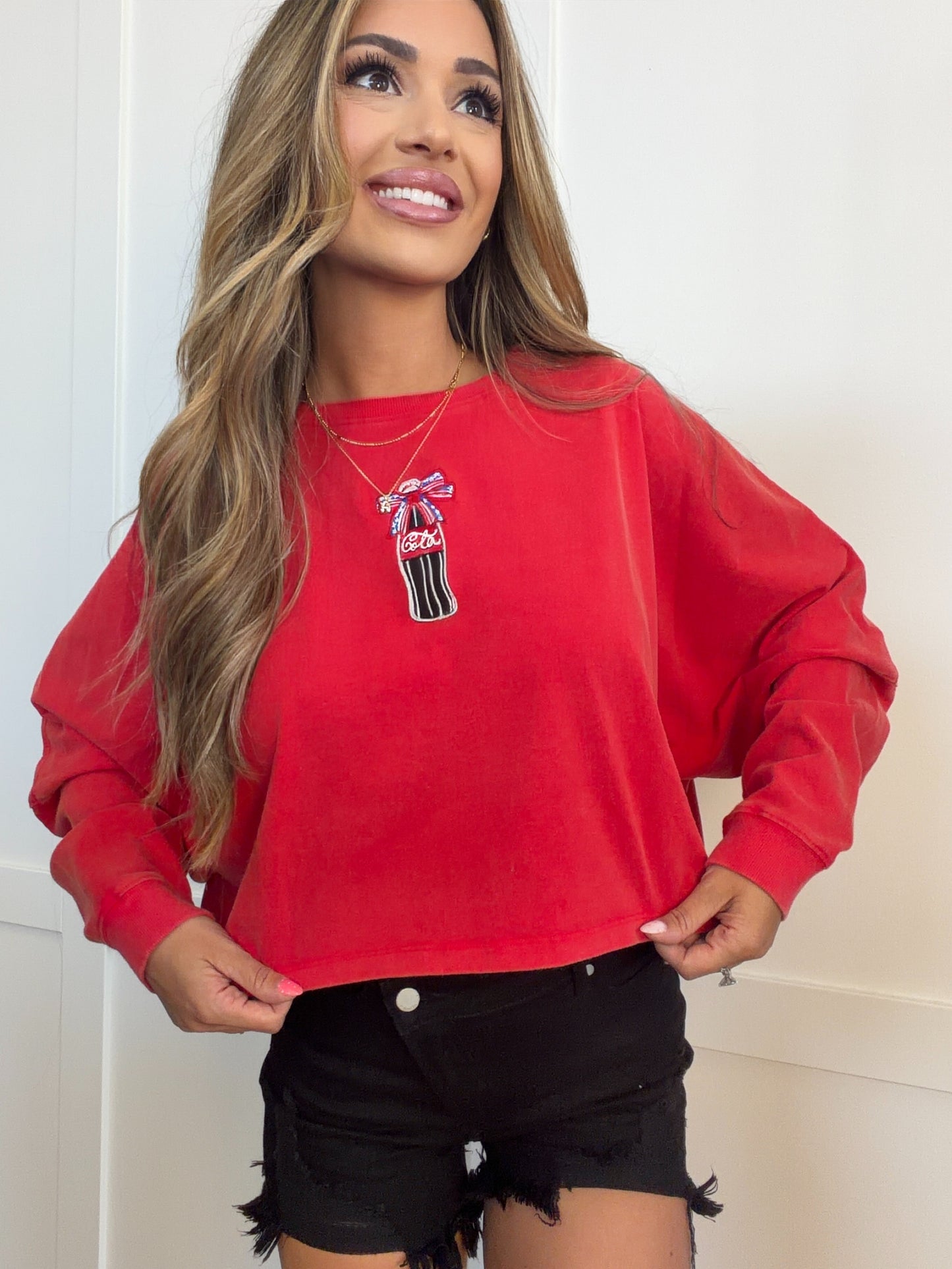 Woman wearing a red sweatshirt with a graphic design on a white background