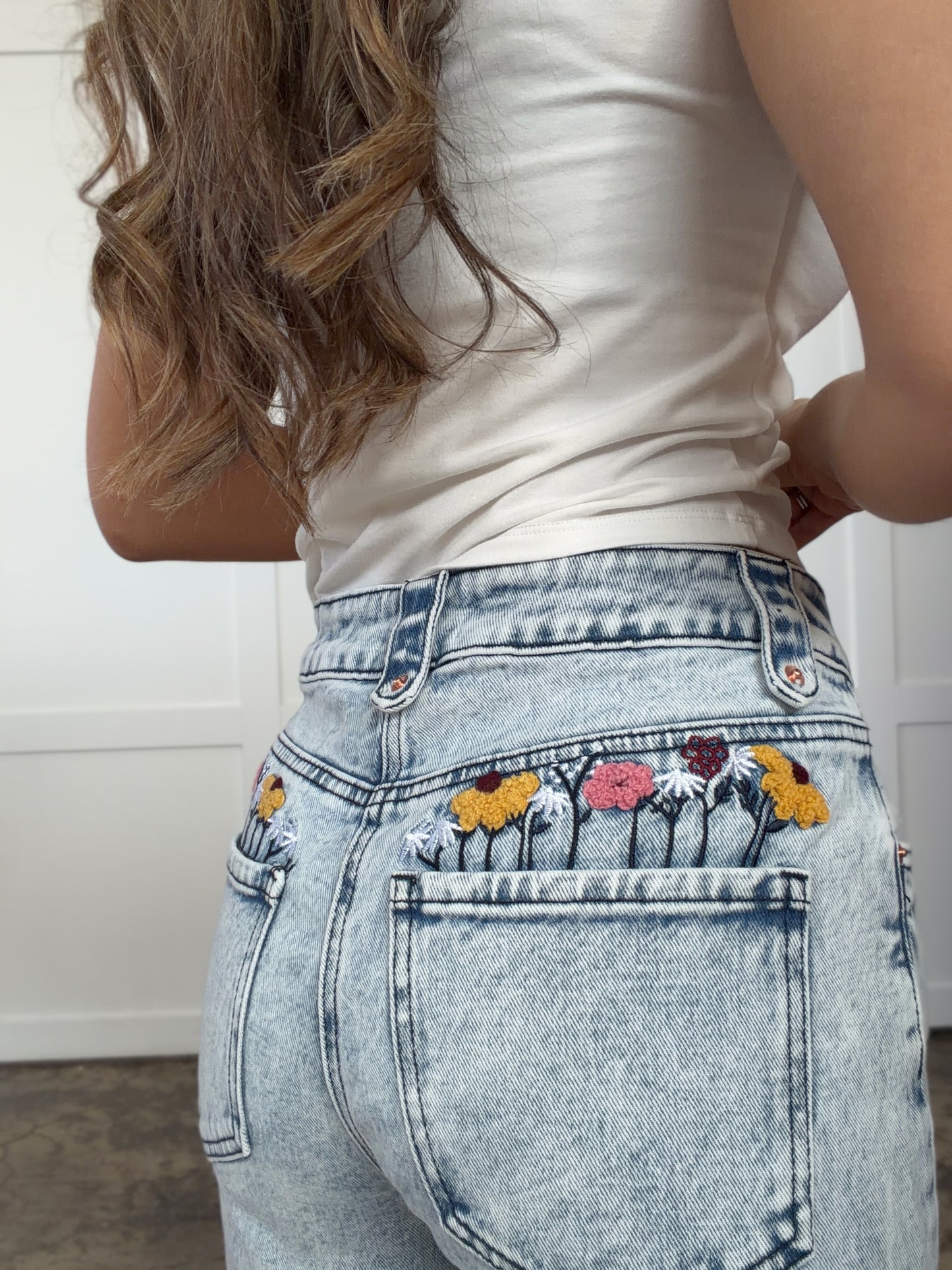 Woman wearing Floral Pocket Denim Jeans in mediumwash shown in front view