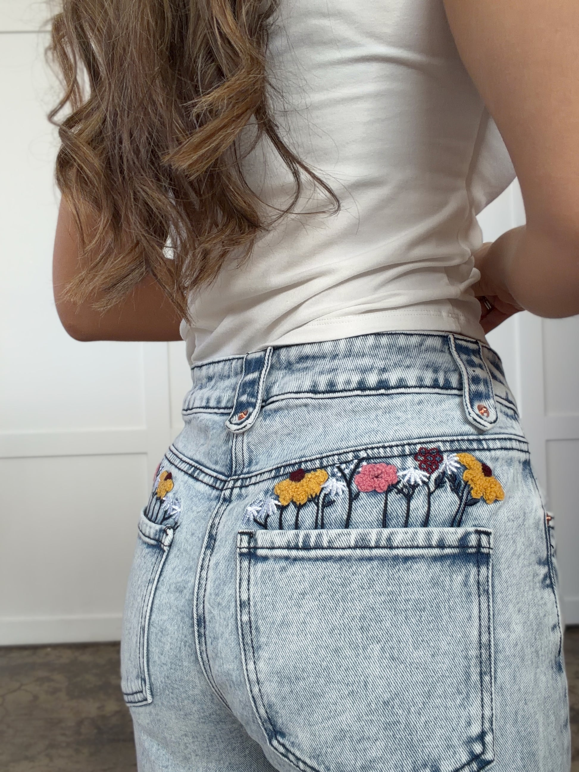 Woman wearing Floral Pocket Denim Jeans in mediumwash shown in front view