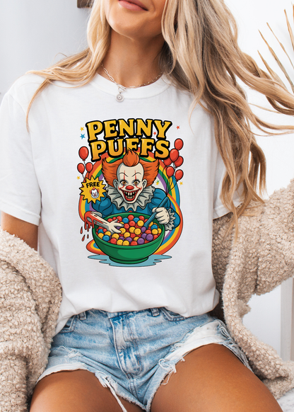 Person wearing a white t-shirt with a colorful graphic design of a clown and text 'Penny Puffs'.