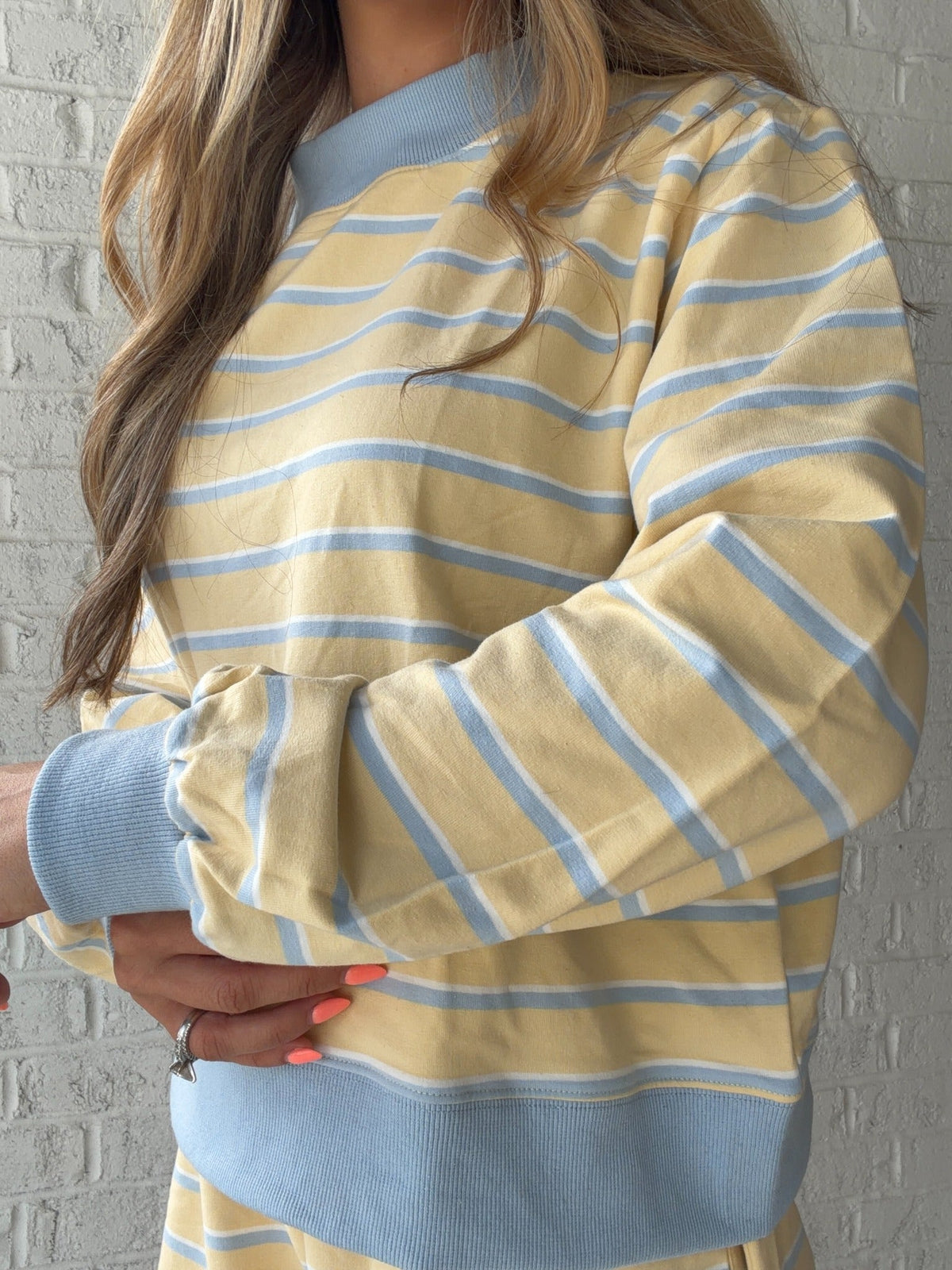 Close detail of the Marigold Morning top's stripes, mock neck, and blue cuffs
